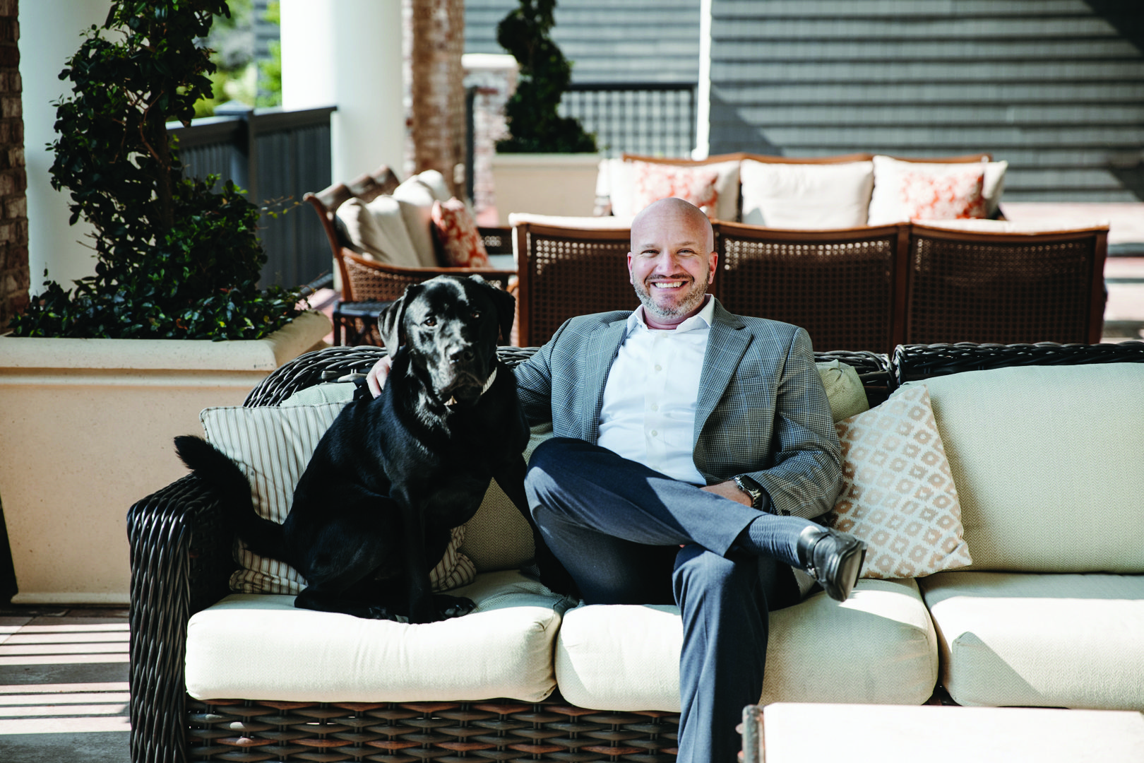Photograph of Ranger, a black Labrador, and David Mars, General Manager of the Henderson in Destin, FL